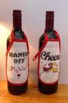 Click/tap for more details of Wine Bottle Aprons - Cheers and Hands Off (cross stitch) by Julie Lynes